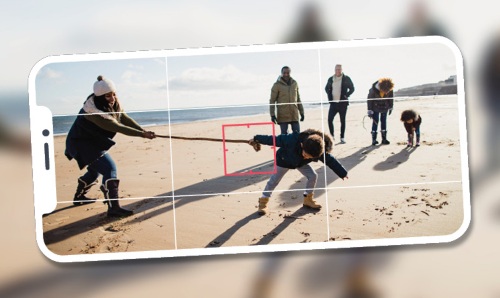 A photo being taken of a family on a beach