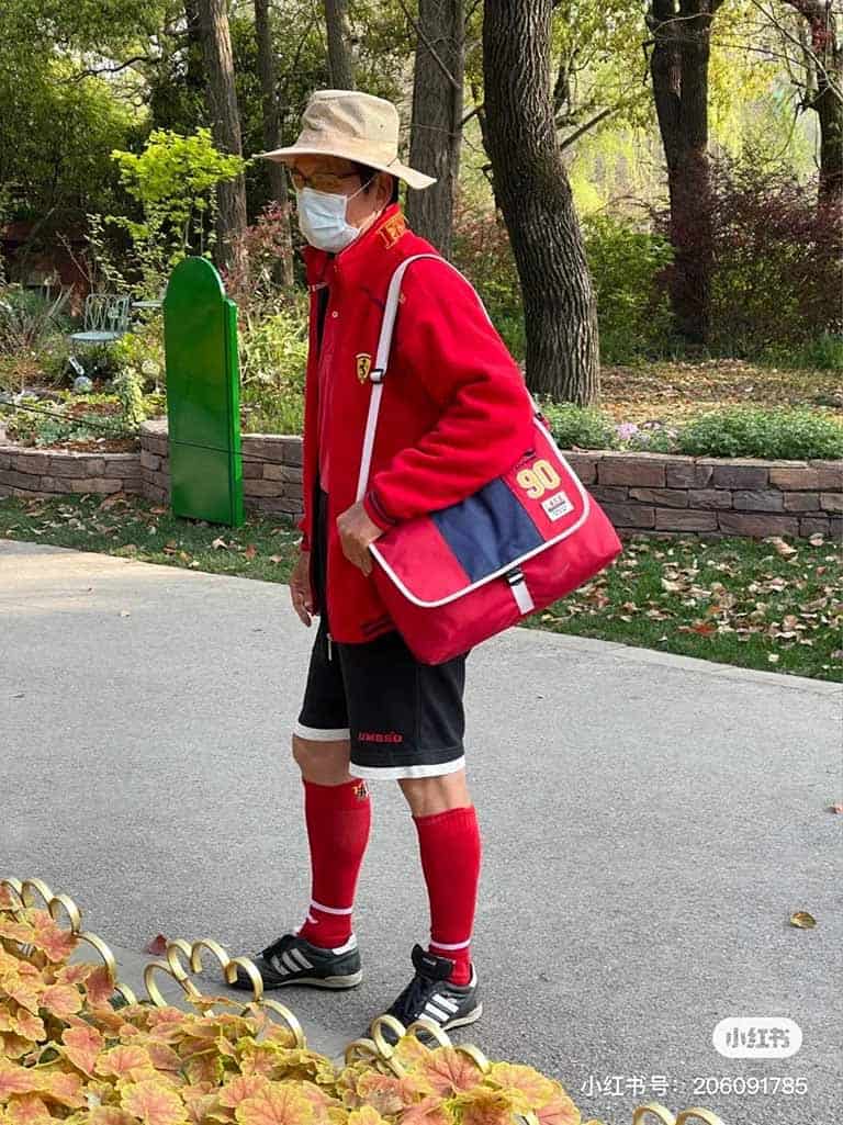 An elderly Chinese man wearing a football themed outfit