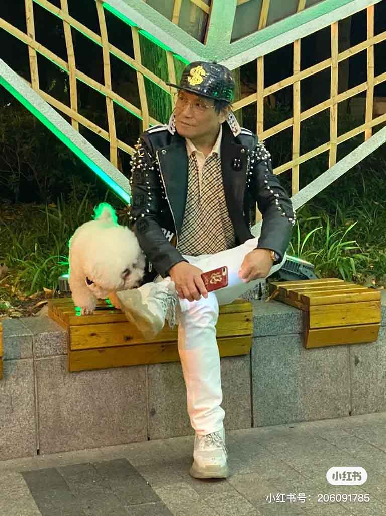 An elderly Chinese gentleman sat with his dog