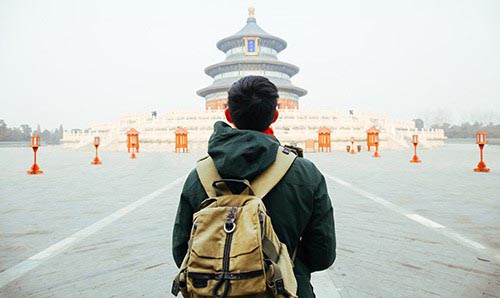 A picture of a student standing in front of a temple
